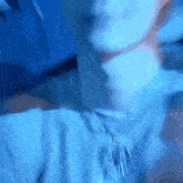 a blurry picture of a person 's face and neck with a blue background