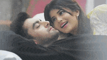a man and a woman are laying on a bed together