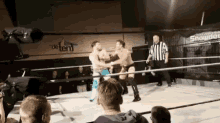 two men are wrestling in a ring in front of a sign that says " de tent "