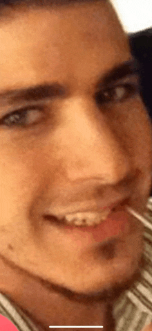 a man with a toothpick in his mouth is smiling