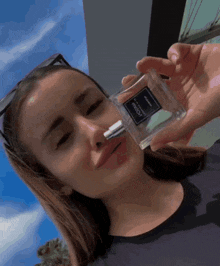 a woman is holding a bottle of aqua perfume in her hand