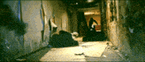 a man is standing in a dark hallway with a sign that says ' a ' on it