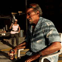 a man in a blue shirt is sitting in a chair holding a can of dr pepper