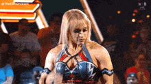 a woman is standing in front of a crowd wearing a blue and red outfit .