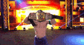 a man is holding a wrestling championship belt over his face .