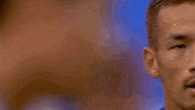 a blurred image of a person 's face with a blue background