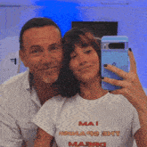 a man and a woman are posing for a picture and the woman is wearing a shirt that says mai