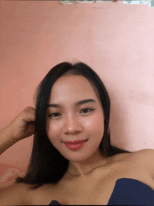 a woman in a blue top is smiling and looking at the camera