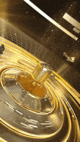 a gold microphone is spinning in a circle on a stage .