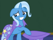 two ponies are standing next to each other and one is wearing a purple hat with stars on it