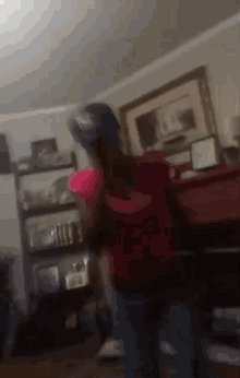 a person in a red shirt is standing in a room