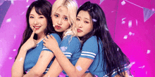 three girls are posing for a picture on a stage with confetti falling around them