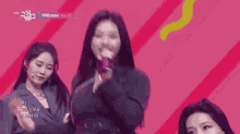 a woman with purple hair is dancing on a stage with another woman .