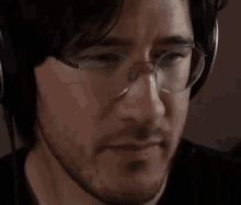 a man wearing headphones and glasses is looking at the camera and says `` smash '' .