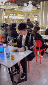 a man sits at a table in a restaurant with a bottle of coca cola on it