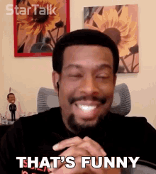 a man with a beard says that 's funny while smiling