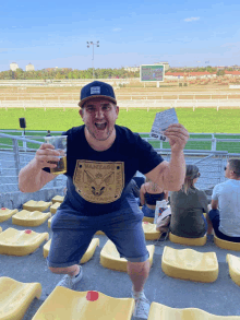 a man wearing a black shirt that says vantage holds up a ticket