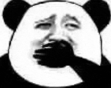 a panda is covering his mouth with his hand .