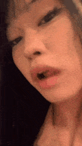 a close up of a woman 's face with her mouth open and her eyes closed