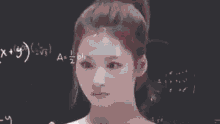 a woman is standing in front of a blackboard with mathematical equations written on it .