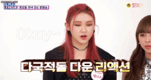 a girl with red hair says okay while another girl looks on