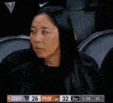 a woman sits in the stands watching a basketball game between the gsv and the phx
