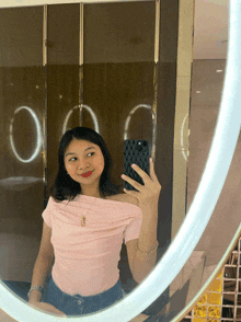 a woman is taking a selfie in a bathroom mirror