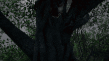 a monster is hanging upside down from a tree