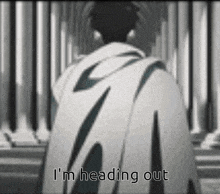 a man in a cape is standing in front of a wall with the words `` i 'm heading out '' .