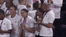 a group of people wearing white shirts that say adidas