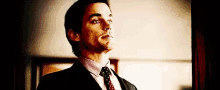 a man in a suit and tie looks up at the sky