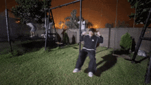 a person is swinging on a swing set in a backyard