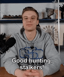 a man wearing a hoodie that says ' good hunting stalkers ' on it