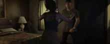 a woman in leopard print shorts stands next to a man in a bedroom
