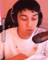 a young man wearing headphones and a white shirt with a heart on it