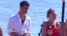 a man and a woman are standing next to each other in the water .