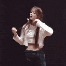 a woman in a white crop top has her hand on her waist