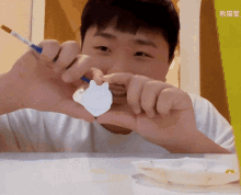 a man is holding a piece of paper with chinese writing on the bottom