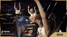 a man sitting in front of a computer with his arms up in the air