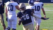a football player with the number 55 on his jersey is running with the ball