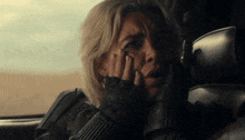 a close up of a woman covering her mouth with her hand