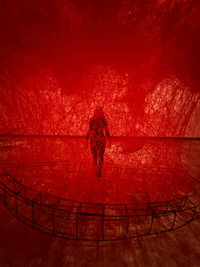 a person standing in a room with a lot of red yarn