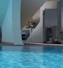a swimming pool is surrounded by a white wall