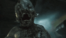 a close up of a zombie with its mouth open and blood coming out of it