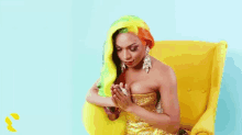 a woman with colorful hair is sitting on a yellow chair