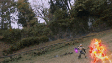 a person in a costume is standing in a field with a fireball in the background