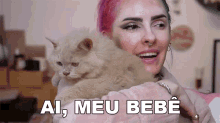 a woman with pink hair is holding a cat with ai meu bebe written on the bottom