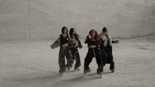 three women with red hair are dancing in front of a wall .