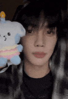 a young man holding a stuffed animal with the letter g on it