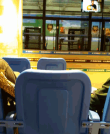 a person sitting in a stadium watching a game with a sign that says rio on it